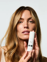 Portrait d'une mannequin femme qui tient dans les mains le Sérum Lift Expert.